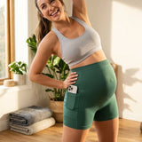 Woman in athletic wear posing in a bright room with plants and exercise equipment.